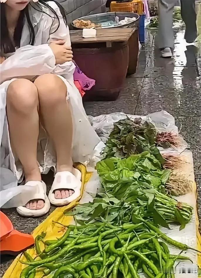 一女子在摆地摊卖菜，有个男子走过来，蹲下，一边漫不经心地挑着辣椒，一边时不时地瞟