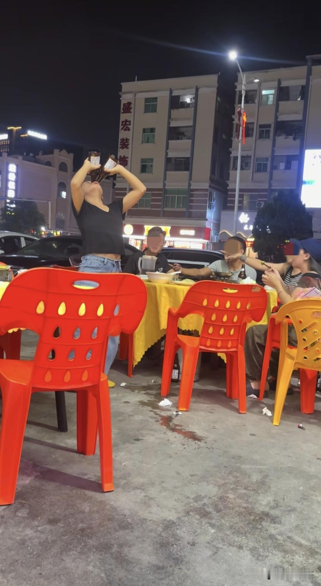 大排档夜市摊上，看到三男两女一起吃饭，其中一个女的为了给大家助兴，玩起了喝啤酒炫