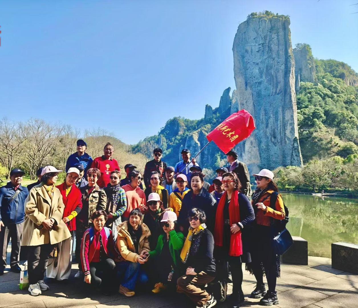 红旗在风里招展，人群与青山绿水同框，把春日的漫游，酿成了鲜活的纪念。