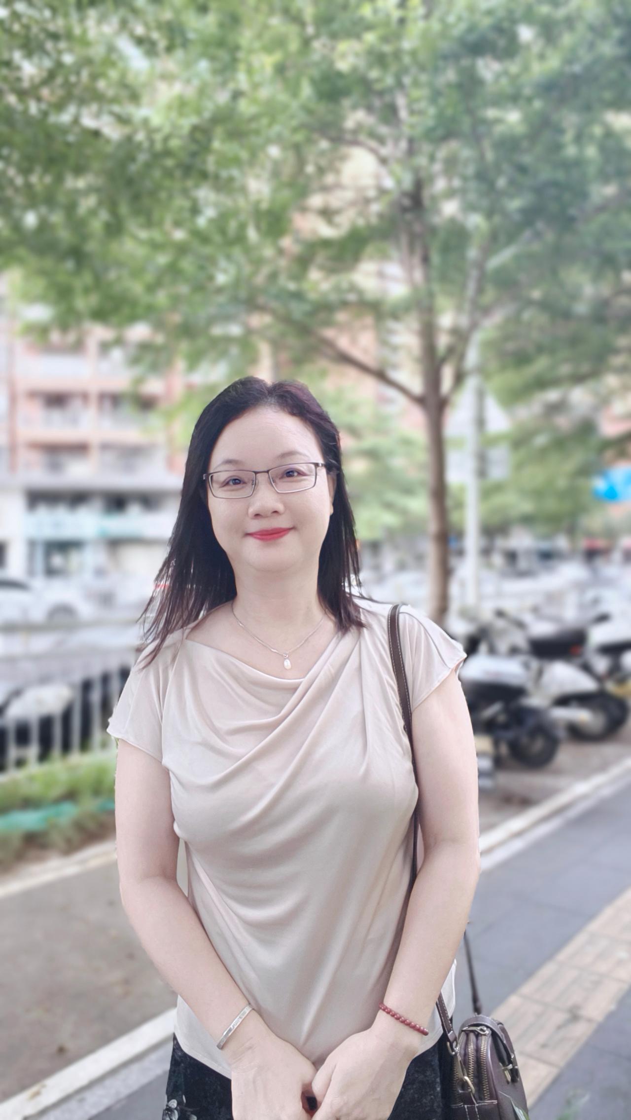 这位女士在户外微笑拍照。