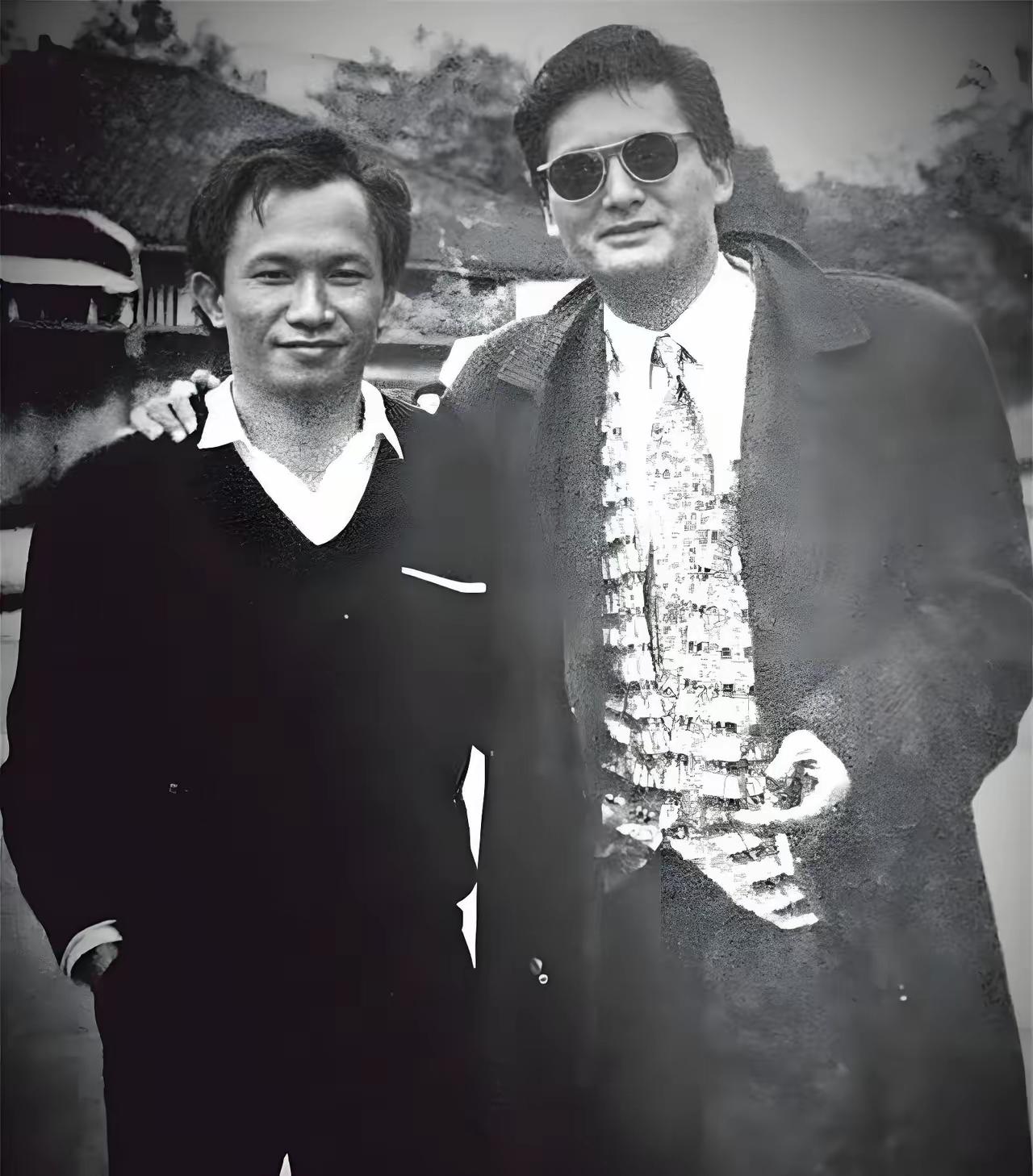 两位男士在户外合影，背景有传统建筑。认识左边这位的不多。经典不复存在。向他们致敬