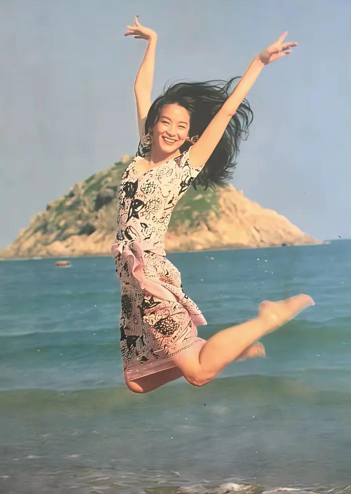 这是林青霞年轻少年时代在海边游玩时，跃起的镜头，照片中充满了青春的活力，活泼可爱