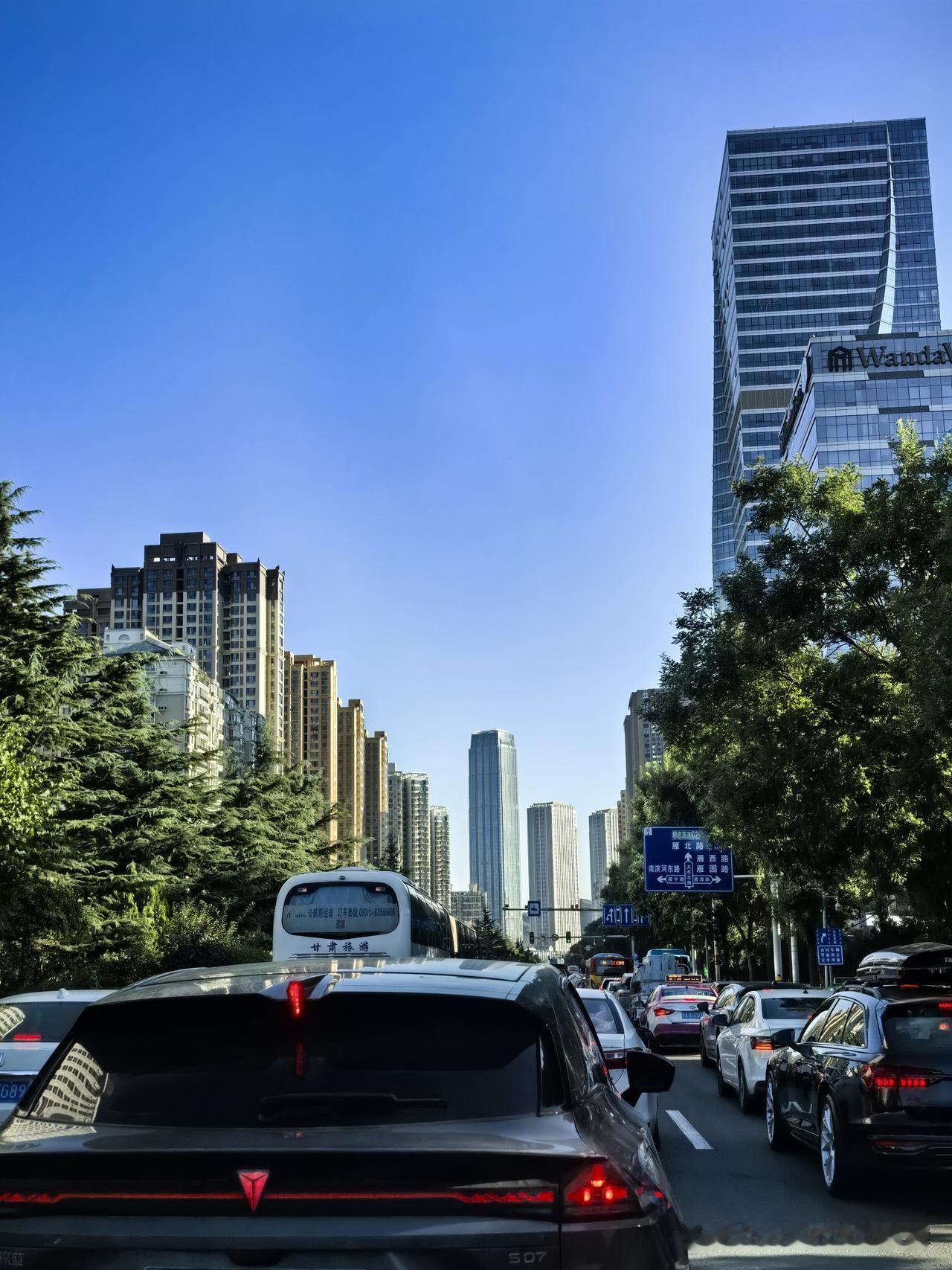 高速沿着祁连山余脉延伸，窗外地貌缓缓变化。一边是成片绿树，一边是沟壑纵横的土黄色