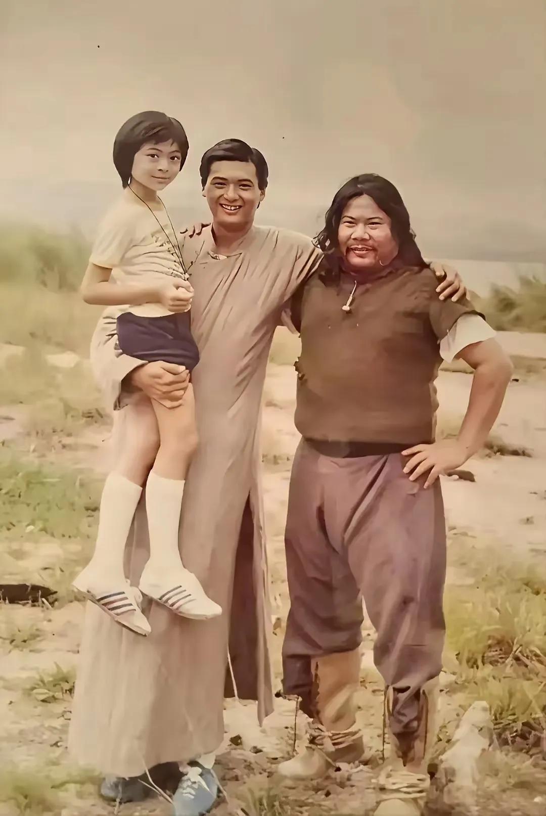 这张照片拍摄于1982年，
当时27岁的周润发手上抱着9岁的樊少皇，
而站在他身