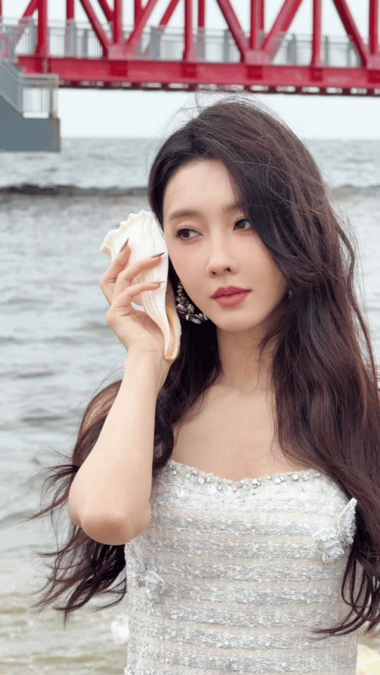 宣璐把浪花穿身上了 宣璐穿着白纱裙站在海边，那画面就像浪花与少女的对话，柔软又动