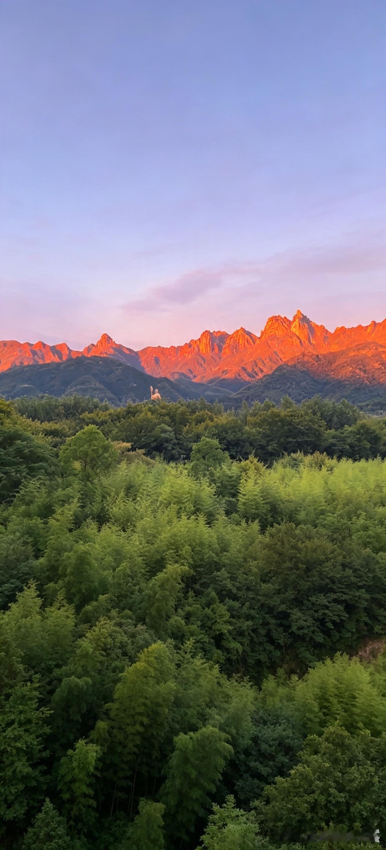 落日熔金，霞光漫过九华山群峰，嶙峋山巅被镀上温暖赤红。层叠青山之下，林海郁郁苍苍