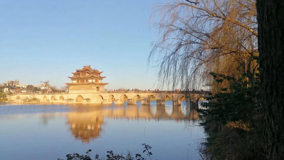 七绝

游云南建水双龙桥有感

廊桥雄距锁双龙，
落日余晖江水融。
翘角楼台牵绿