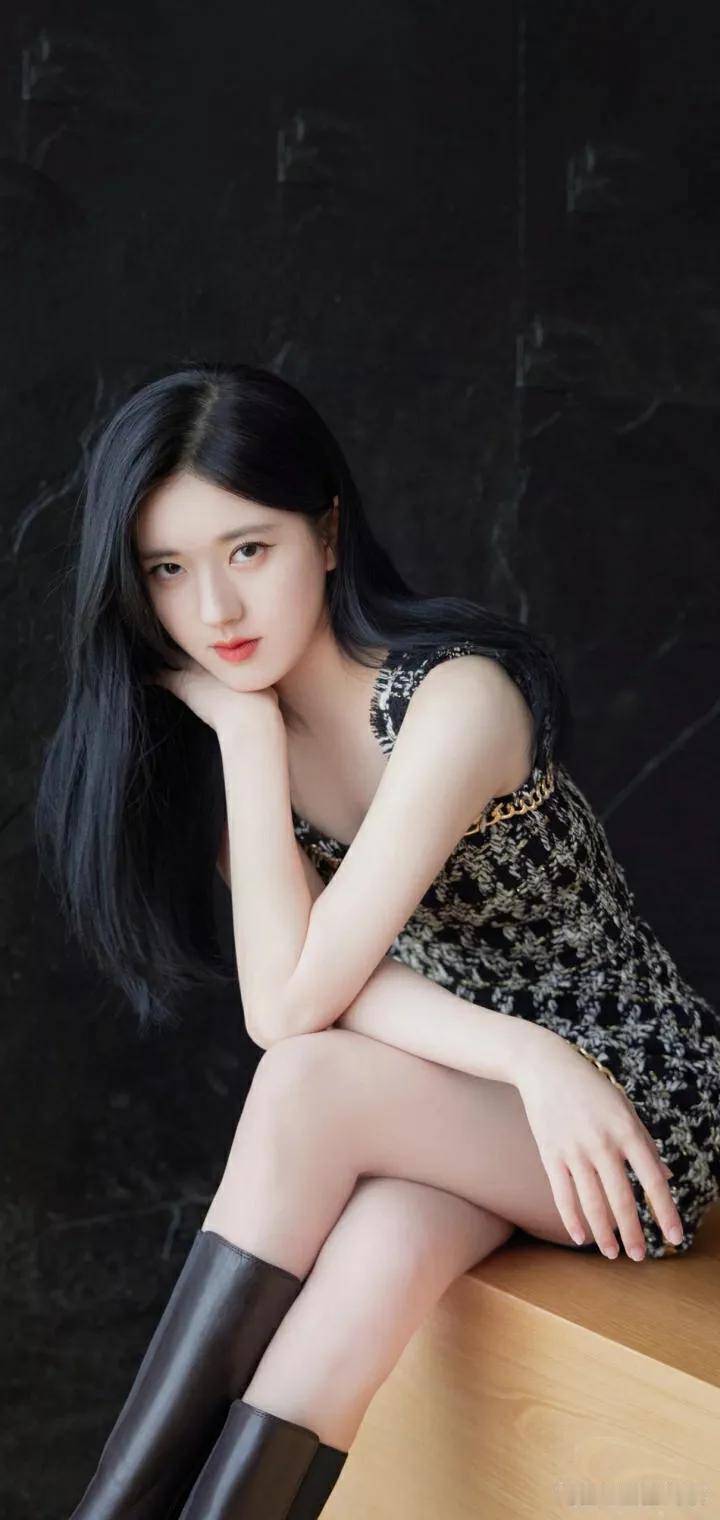 我在街头偶遇一位优雅黑裙少女，她沉静如水，气质非凡。那身黑裙仿佛量身定制，完美勾