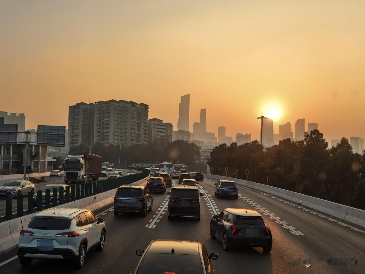 广州日落·城市晚高峰
落日熔金，将广州天际线染成暖橙，车流在高架上缓缓流淌，楼宇