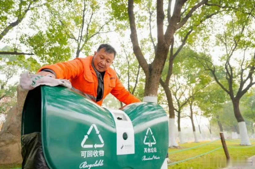 【合肥街头新增了一批果皮箱】近日，在合肥蜀山区天鹅湖西路人行道旁，环卫工人正仔细