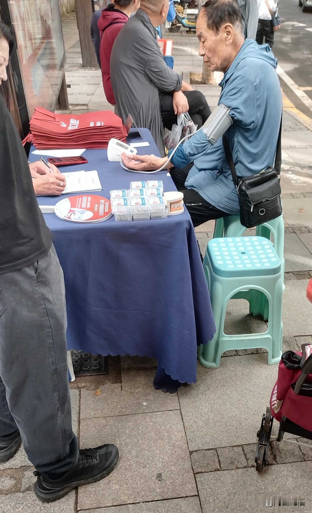 图中这位大爷，听到免费量血压，大热天二十五六度，刚走过来脸还红着，坐下就量。
我
