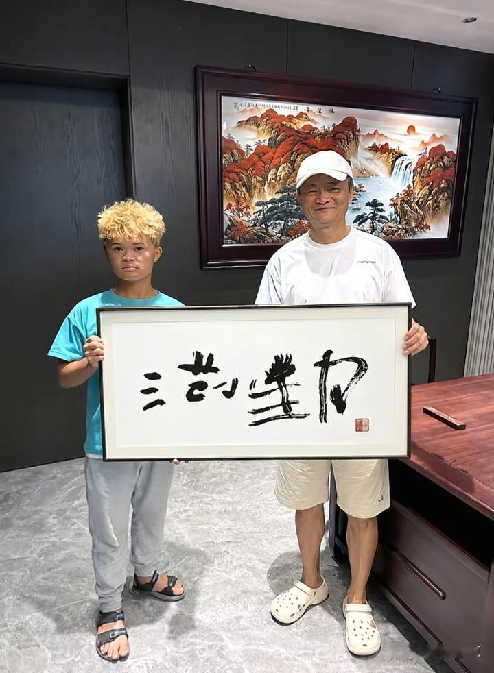 万万没想到，网红小马云终于见到了“本尊”，还开心收下亲笔题字。
两个人站在一起，