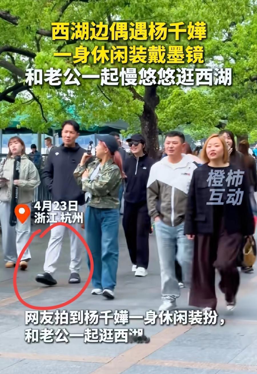 杨千嬅与老公在杭州逛西湖，丁子高穿一双拖鞋就出来了，还穿着白袜子很奇怪，还不如光