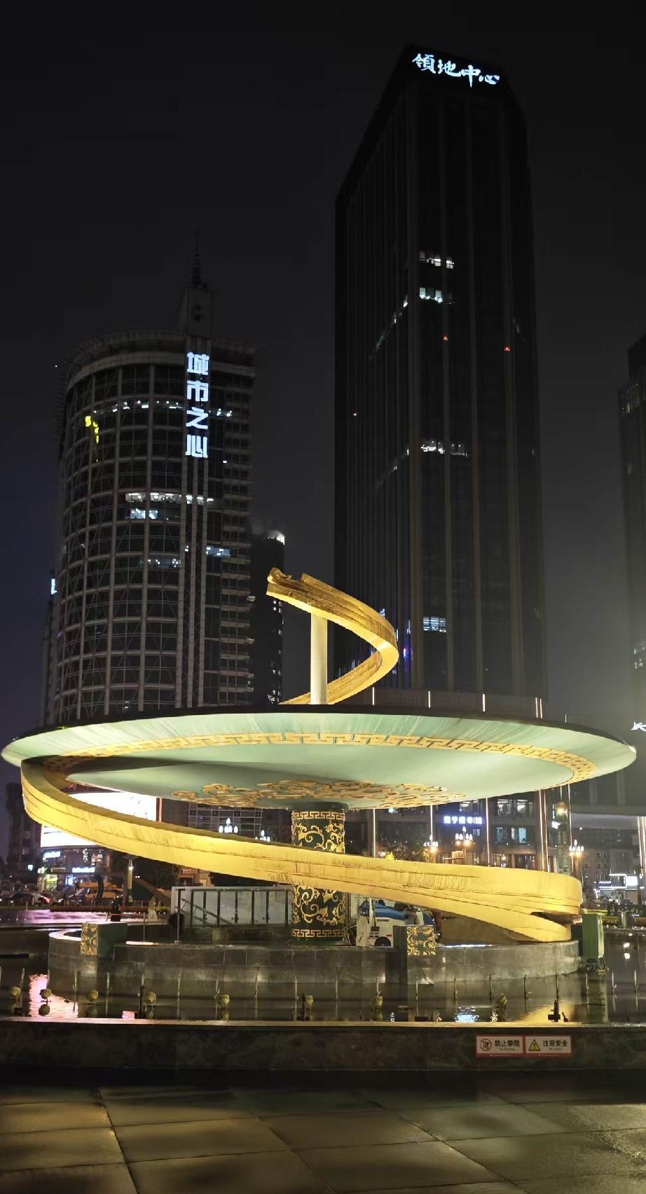天府夜色
 
金带盘旋，向上舒展
夜色漫过广场青石地面
雕塑静静立在城市中央
 