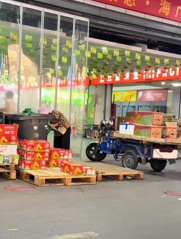 嘉兴水果市场一角，一位老阿姨在捡商家丢掉的水果。

看这位阿姨的装备，不像是捡来