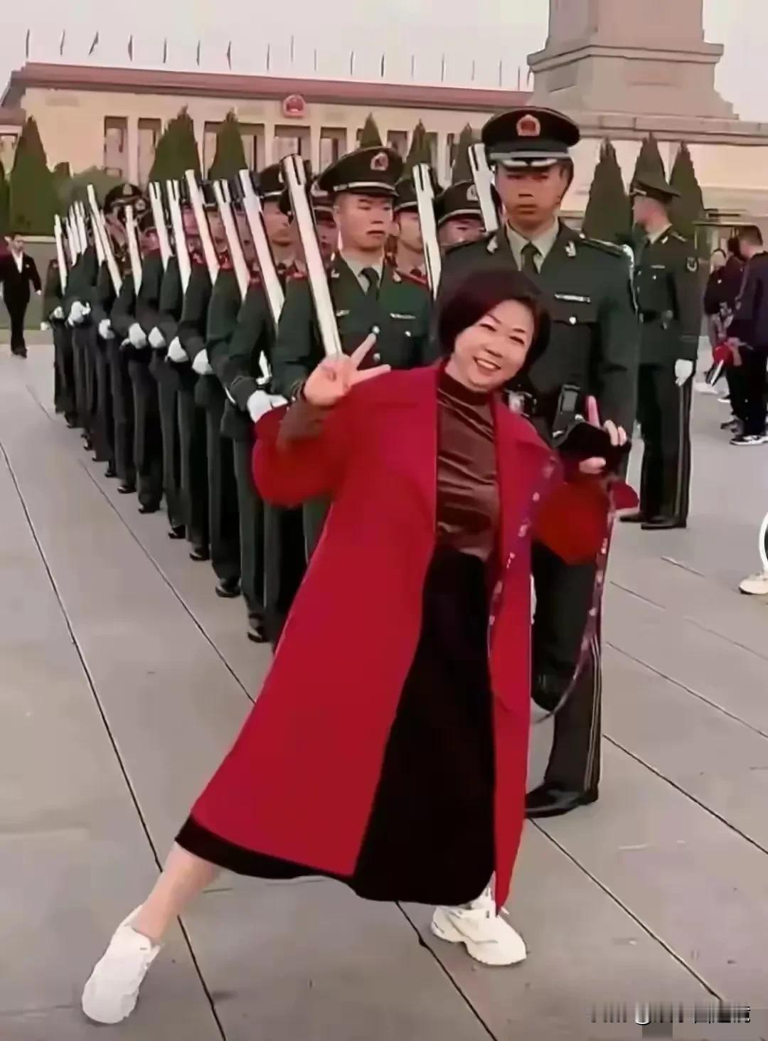 照片中这个大妈的动作确实有点过分了，在这么严肃的场合，竟然挡在队伍的前面抢镜头，