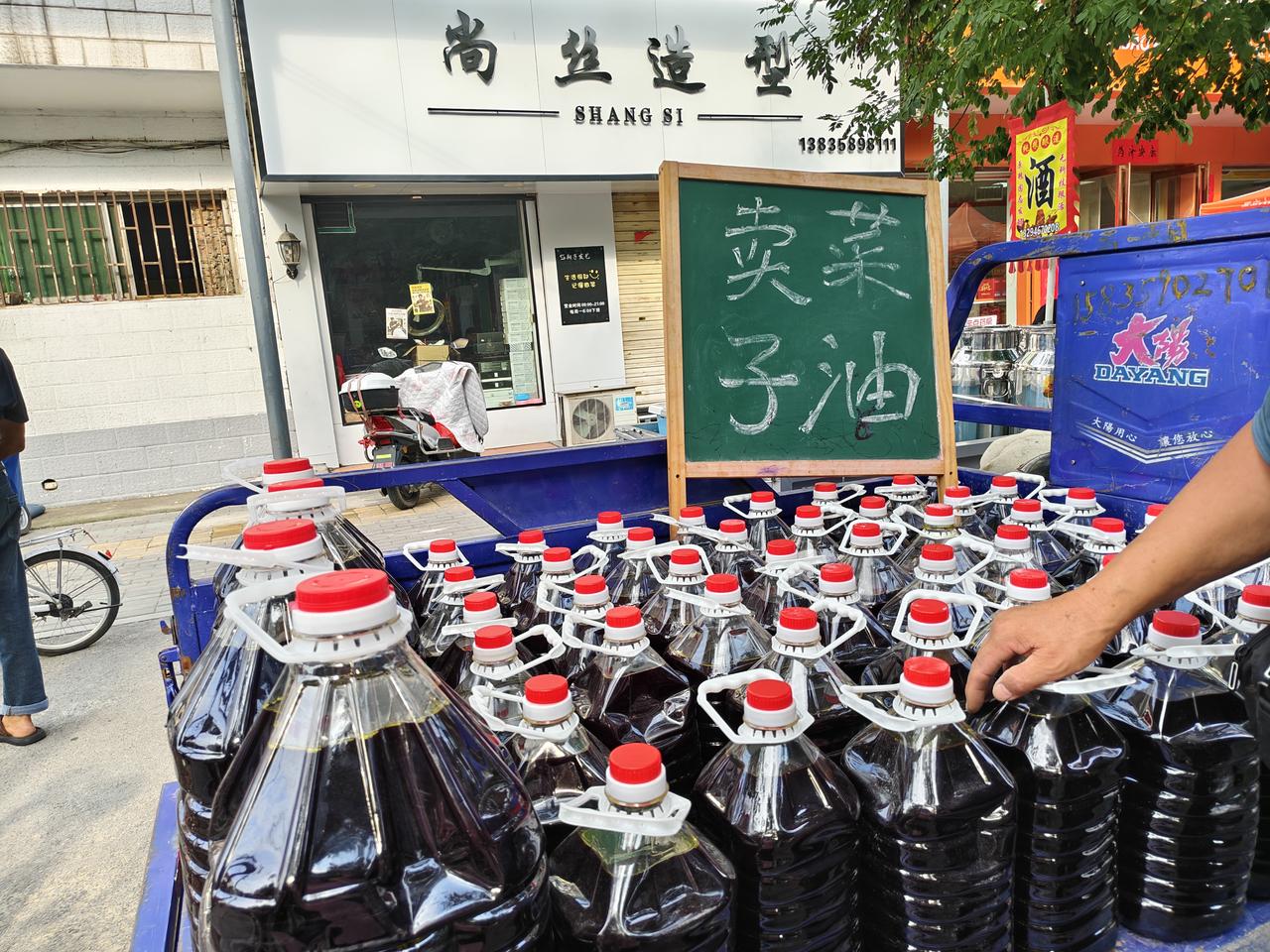瞧瞧，这位师傅自家榨的菜籽油，9元一斤，一小桶是80元。（9斤）我想买，但拿不了