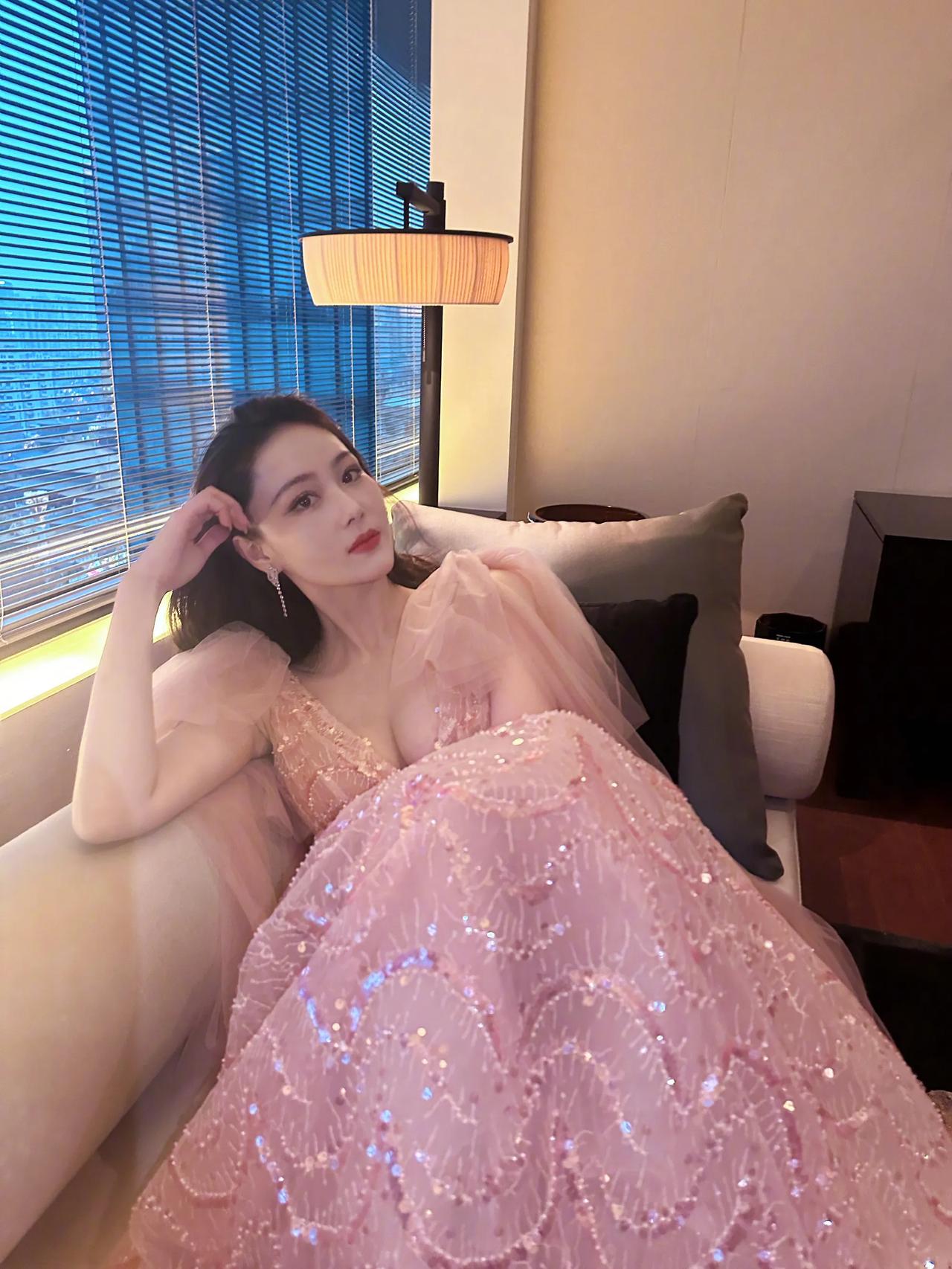 张馨予穿粉色裙子窝在沙发上，深v设计大秀傲人胸围。张馨予五官精致，身材又好，妥妥