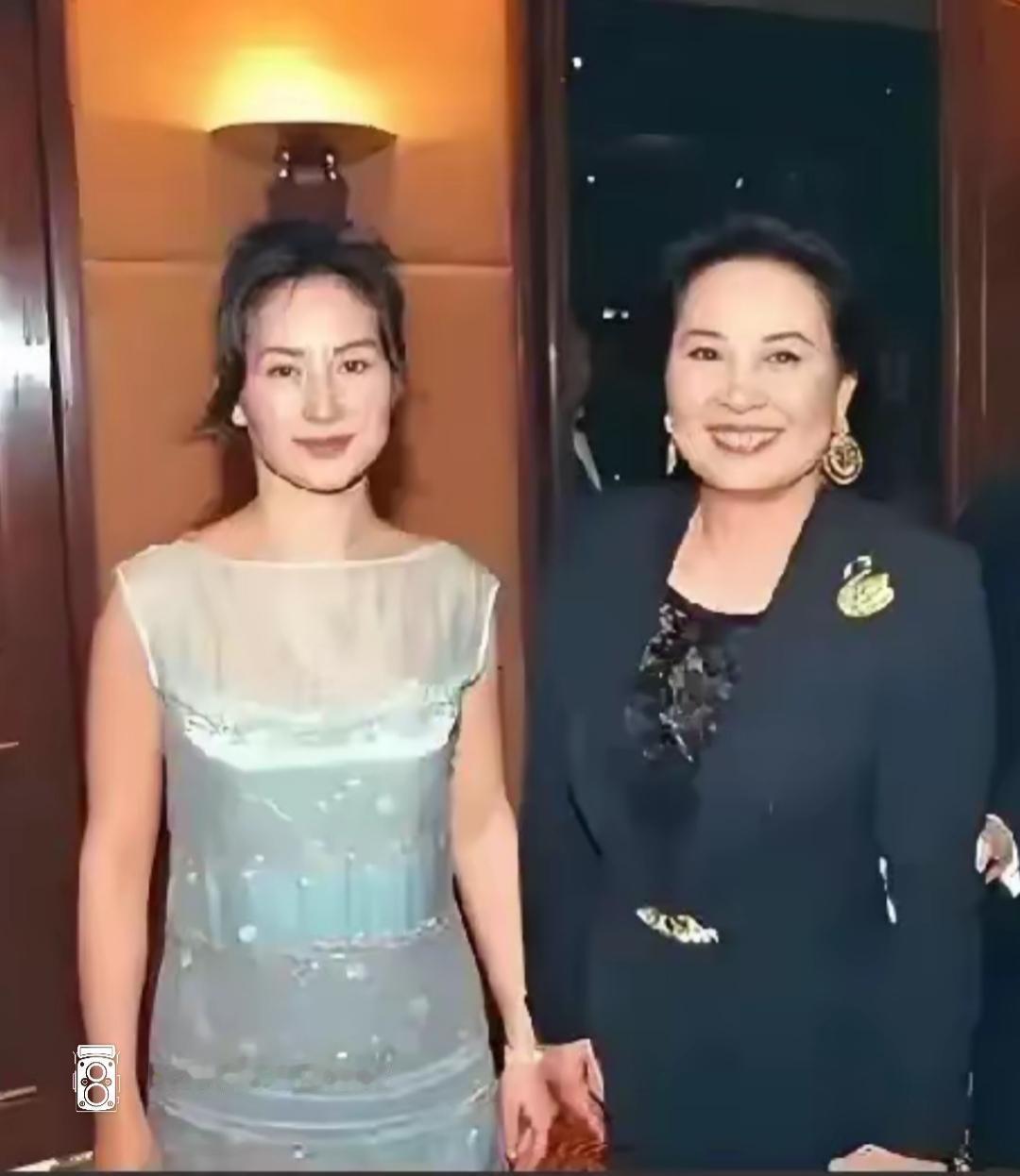 两位女士在活动中合影，看起来很开心。母女俩的仪表颜容都很高尚。基因强大，那时候真