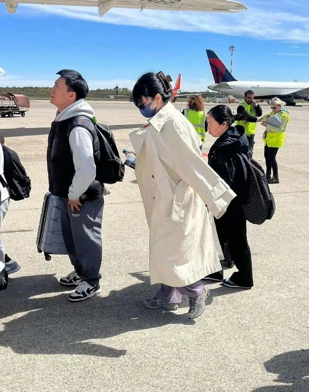 王菲从国外回来了，穿卡其色风衣，内搭黑色打底衫，下搭灰色阔腿裤，打扮得比较随意，