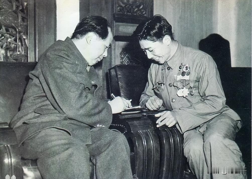 1951年10月29日，志愿军战士孙伯启盯着小本子看毛主席给他签名，主席还给他一