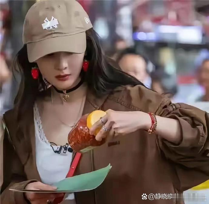 杨幂参加活动，把帽子上的标用胶带粘起来了，不过好像没什么用吧，有谁会不认识吗  