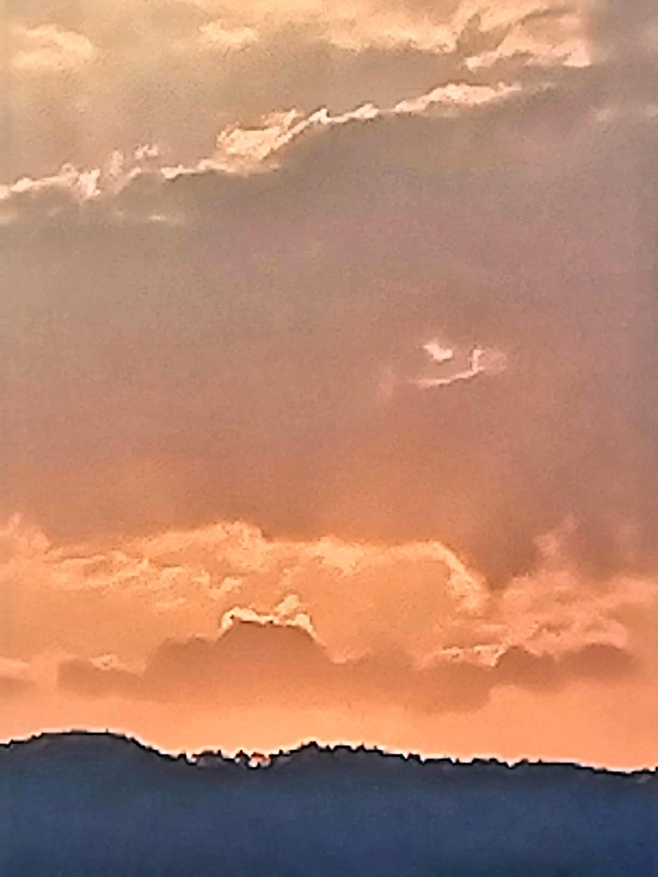 夕阳西下，云海翻滚，静谧而壮丽。橙红色的余晖洒在翻滚的云海上，像是给这片云海披上