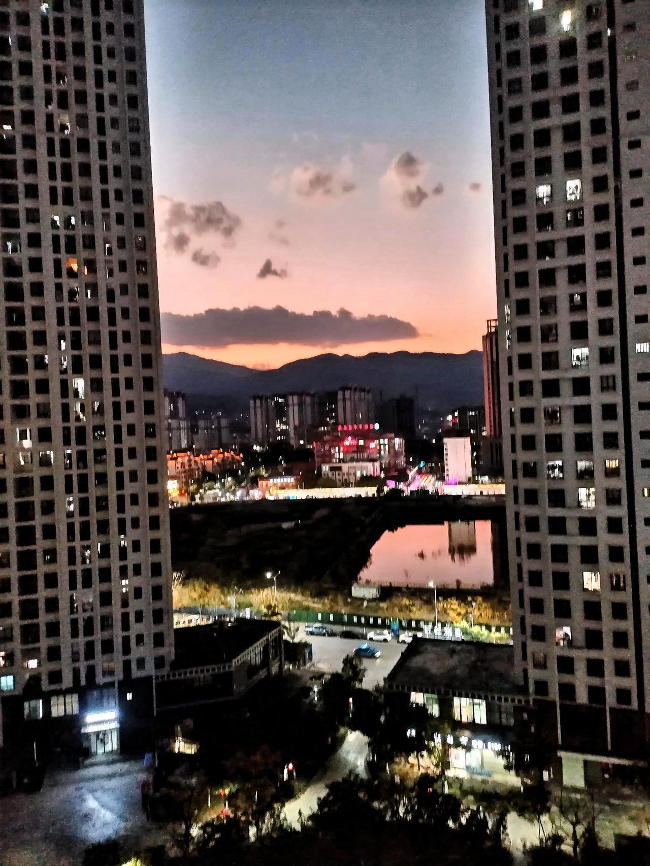 城市黄昏，灯火阑珊，静谧而美丽。街道上，路灯渐次亮起，与天边那一抹橙红余晖相互映