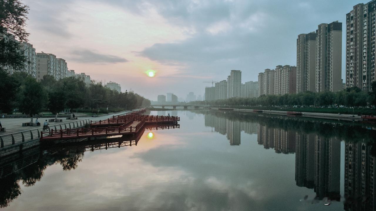 清晨，抱龙河很静。太阳从东方升起来，河面上映出它的倒影——那是一团金黄色的光环。