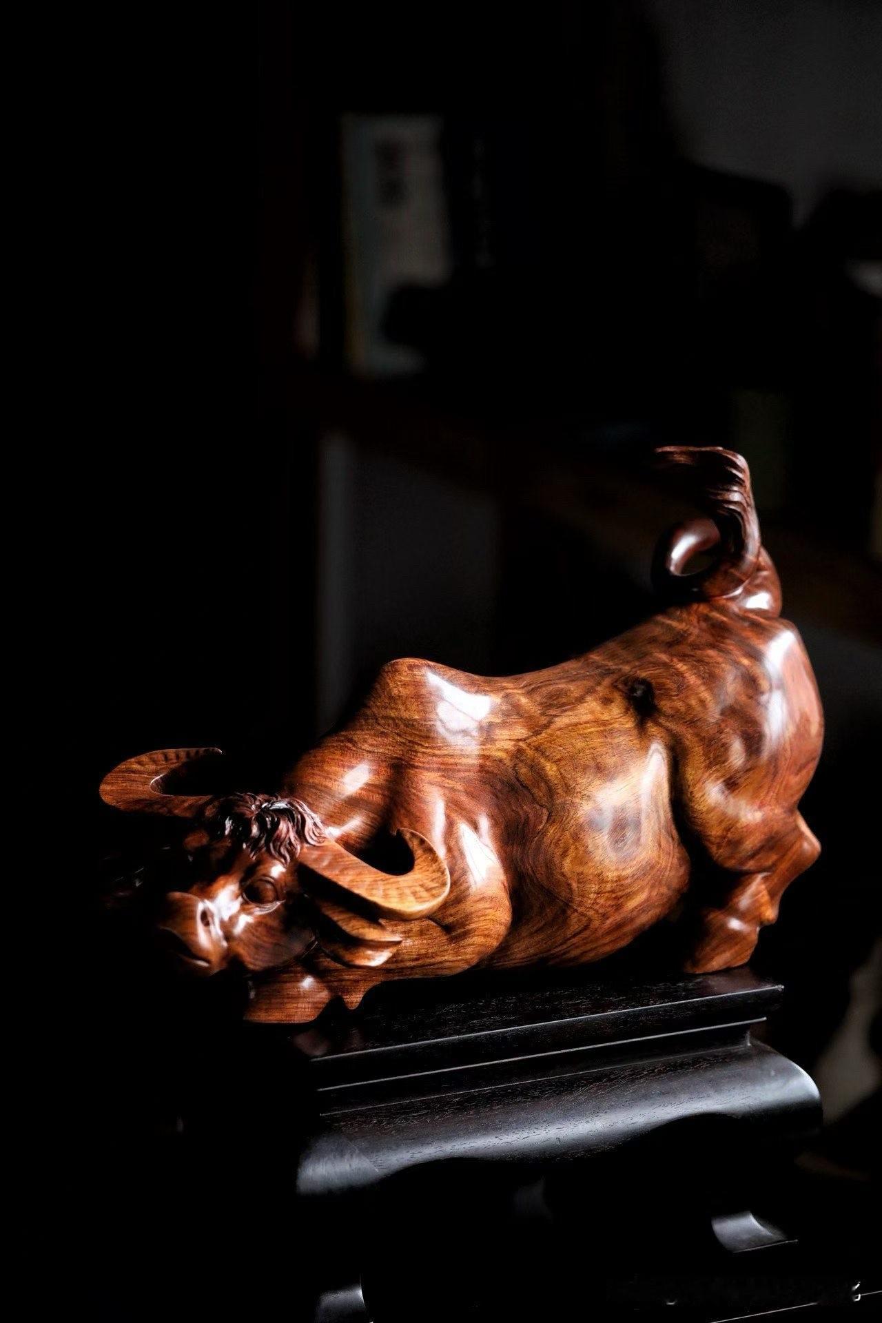 这头牛，不急着“发力”，却气势在那。

海南黄花梨的水波纹，
在光下缓缓流动，