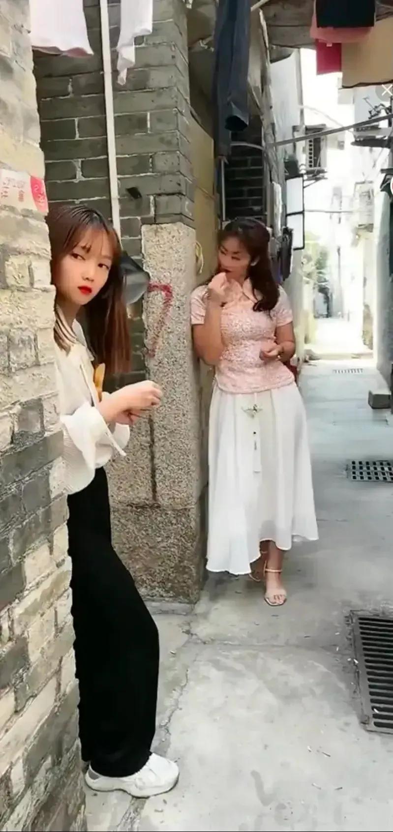 两个女孩年轻漂亮，但为什么不上班呢！在这里等待什么呢？