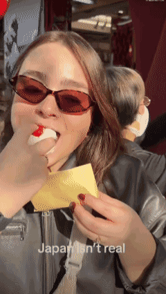 一名美国女人在日本旅游时在街头吃麻薯，结果转眼就看到身后一家店挂出了“禁止饮食”