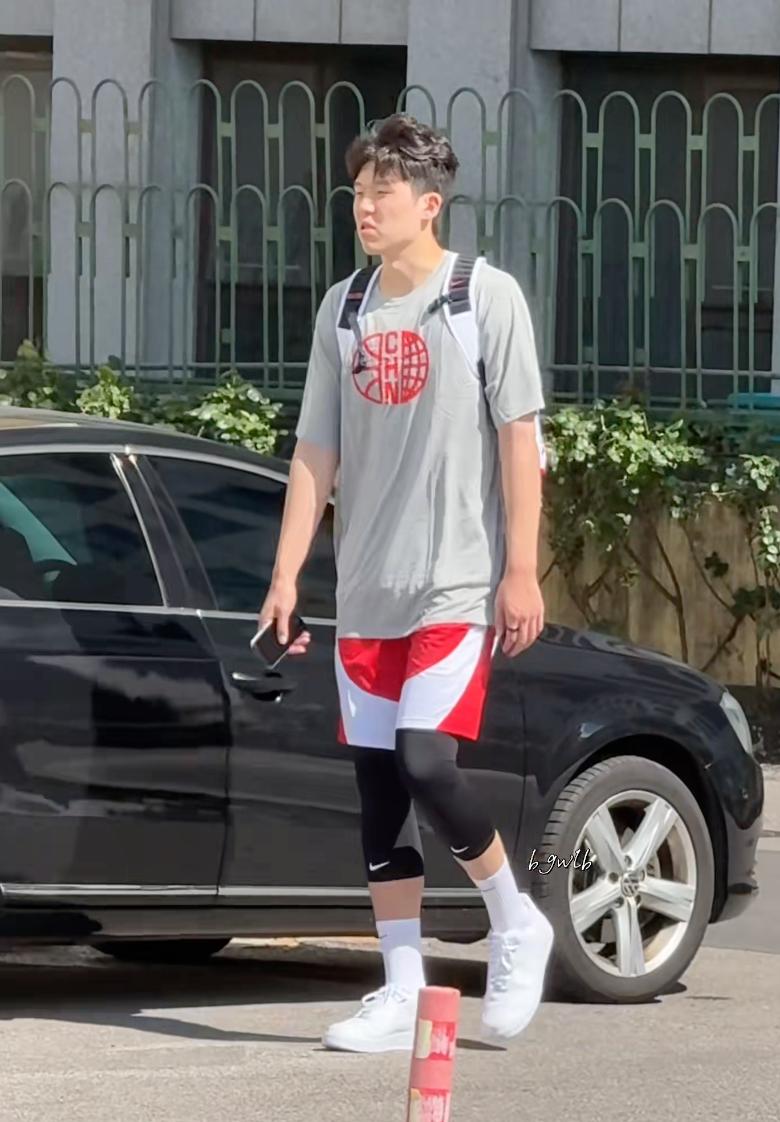 一脸班味！杨瀚森现身中国男篮训练营，穿着国家队队服背着背包，小杨看起来还没睡醒。