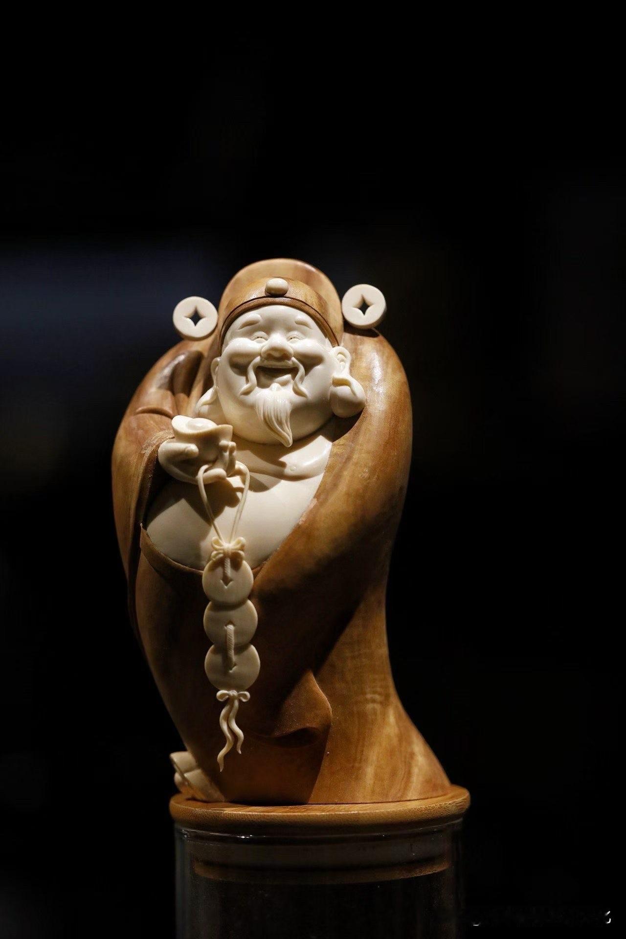 这尊“财神爷”，第一眼就很讨喜。

老山檀为衣，猛犸为容，两种材质一深一浅，相互
