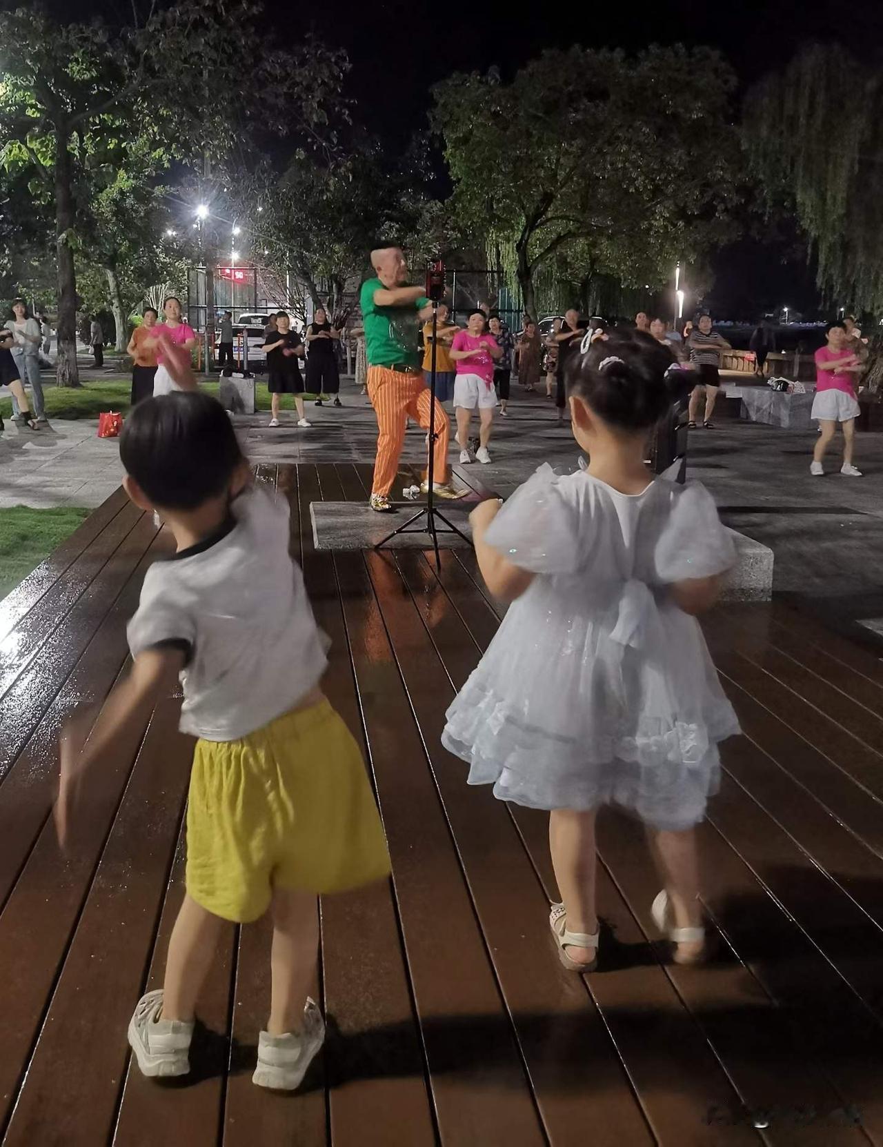《江畔共舞》
中江的河畔夜色温柔，广场舞的旋律响起，大人们踏歌起舞，两个可爱的小