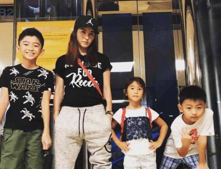 张柏芝身旁的小女孩长得有点像她，四人合影，颇有一家人的感觉。