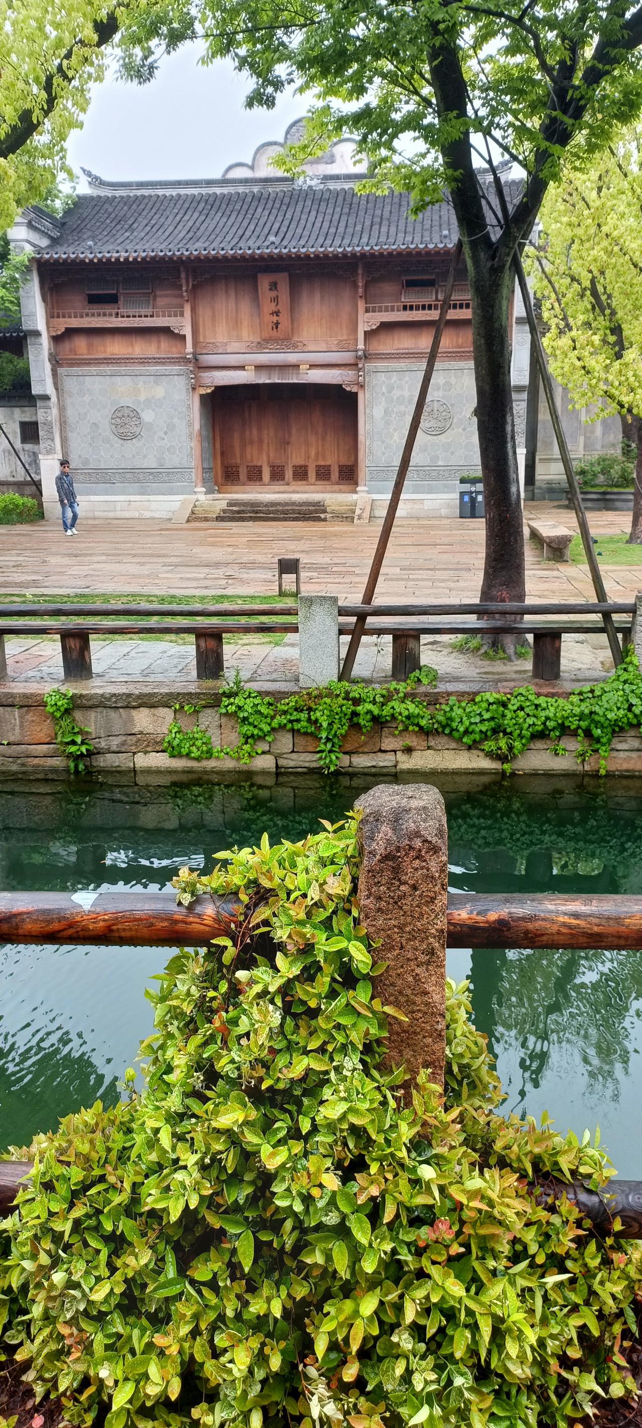 古色古香的庭院，绿树环绕，静谧祥和。
上联:绿树掩映古桥边，
下联:静听流水入梦