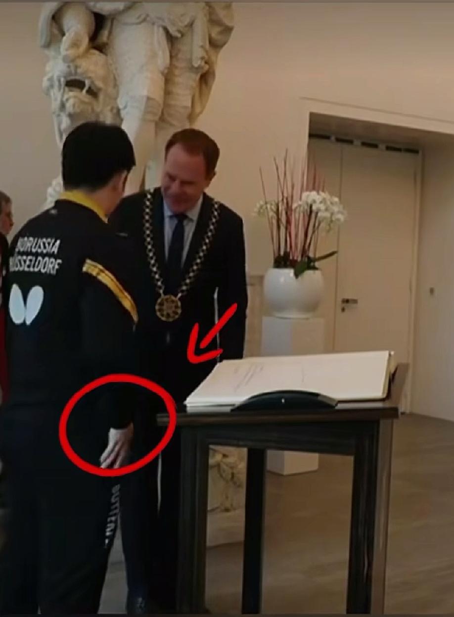 樊振东是个讲究人，
在他签完名后，先是在自己的衣服上擦了擦手，在和市长礼貌谦虚的