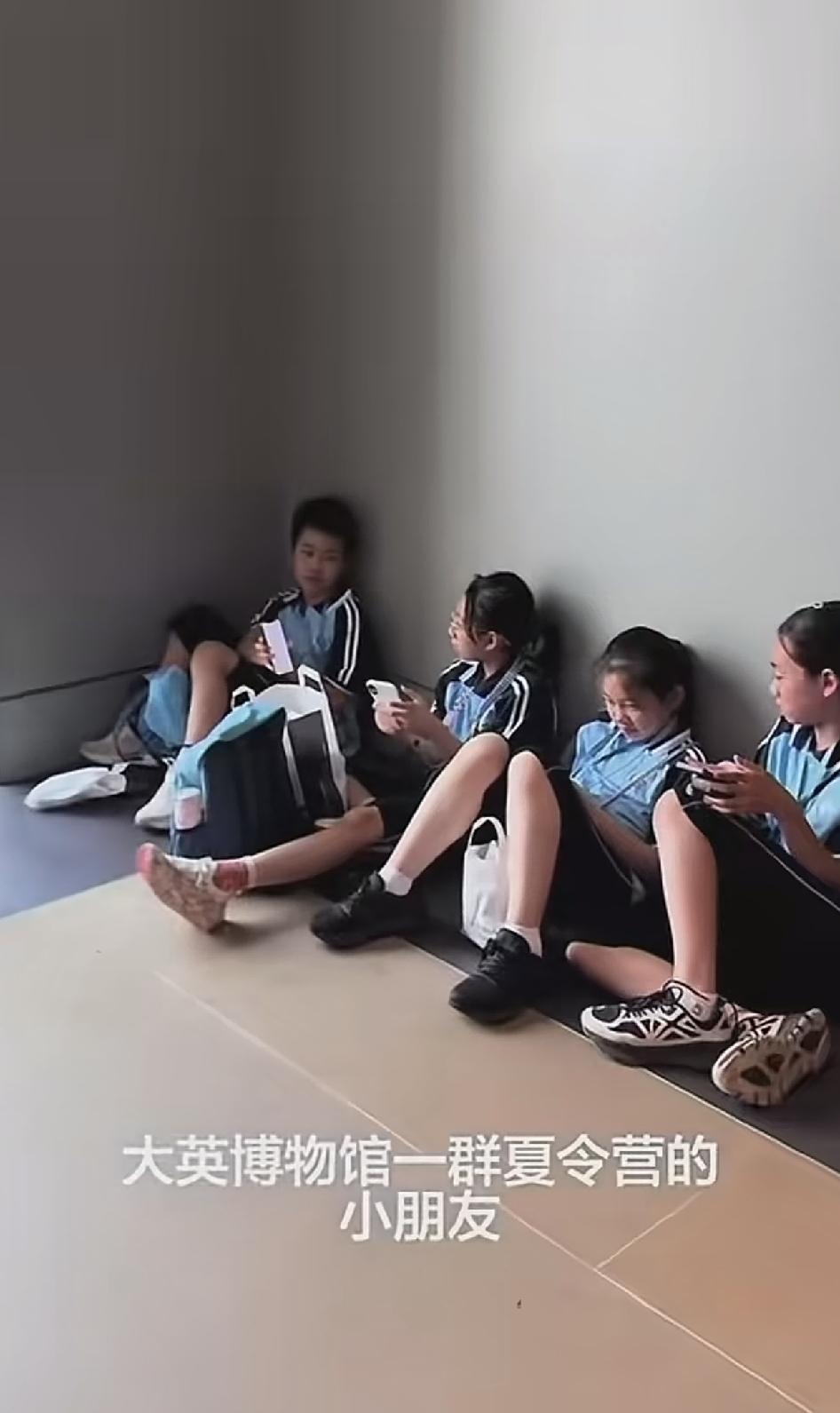 网友在大英博物馆，看到一群来自中国的小学生，席地而坐玩手机。有网友感慨，这些孩子