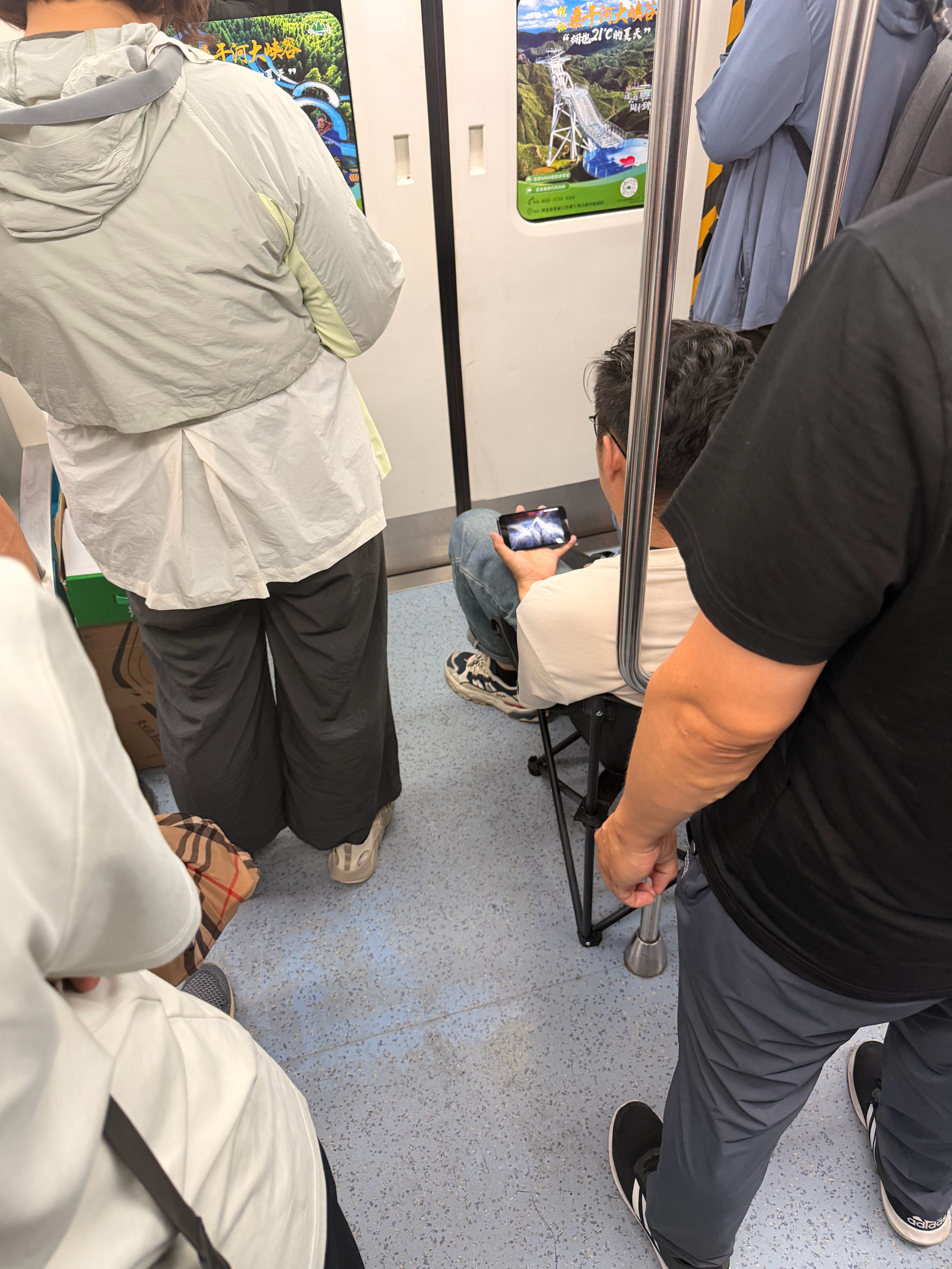 地铁里拿着凳子的见过不少，但都是小折叠凳，但这哥们，真把地铁当他家了，这么大的折