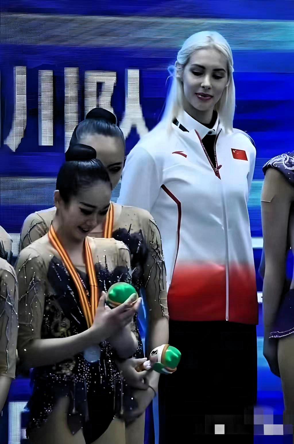 这是中国艺术体操队的俄籍外教阿纳斯塔西娅·布利兹纽克，她正和队员们在一起。
在2