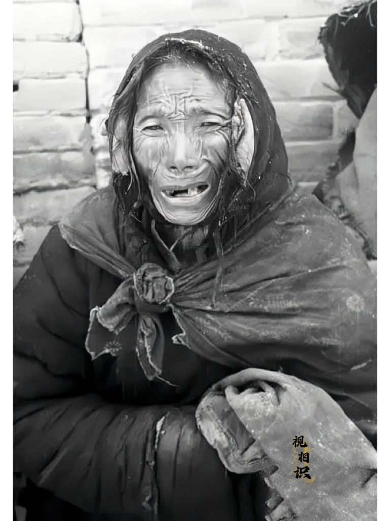 1942年，河南大饥荒，一位逃荒老人的照片，画面中她身上的衣物破旧污秽，脸上皱纹...