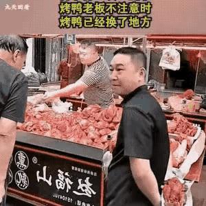 这是一个惯偷。趁摊主转身把秤时，他顺手拿走整只烤鸭，并包纸藏在身后，然后若无其事