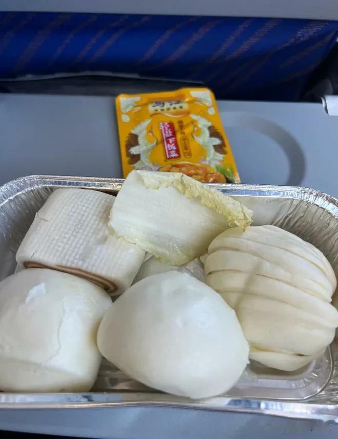 这该不是飞机乘务员配餐搞错了吧，几个馒头和一片白菜，虽然经济形势下滑，航空业不景