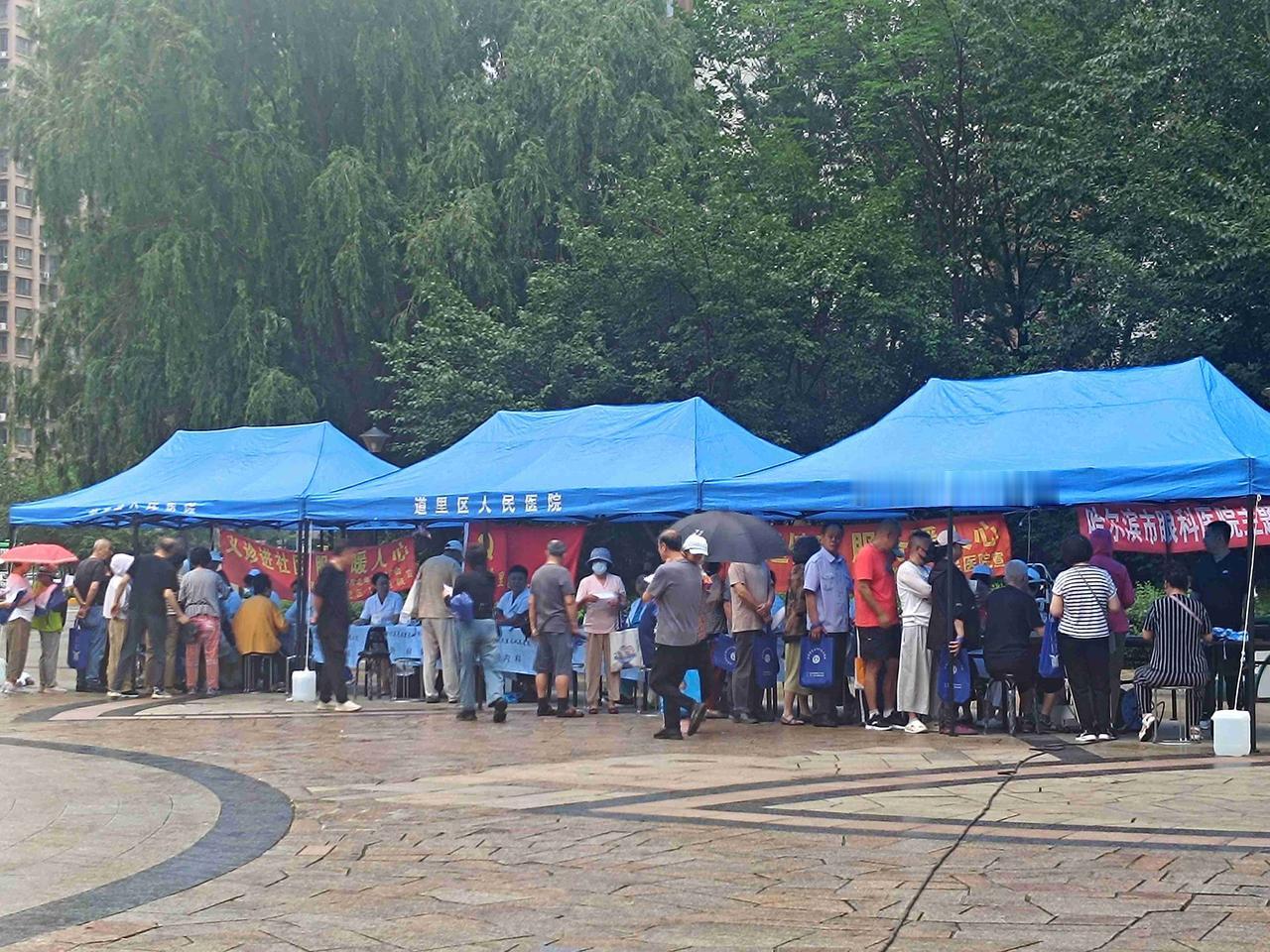 雨天送健康，义诊暖人心。道里区人民医院来小区开展巡回医疗服务，即便细雨绵绵，前来