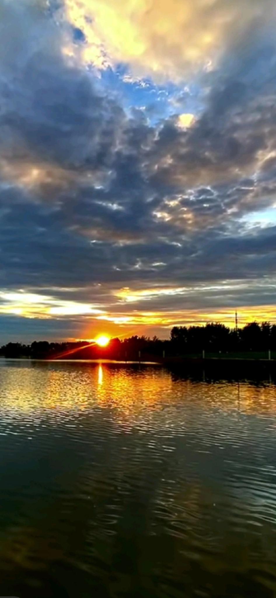 云隙里的金
 
傍晚路过湖边时，风先递来了凉意——夏末的黄昏总这样，白日的溽热刚