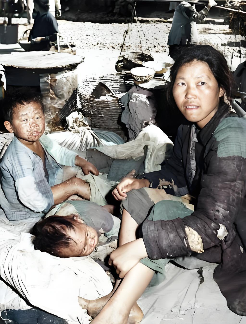 这张照片是1946年6月在镇江拍的，你看画面里，一个妇女穿的衣服破得全是补丁，身