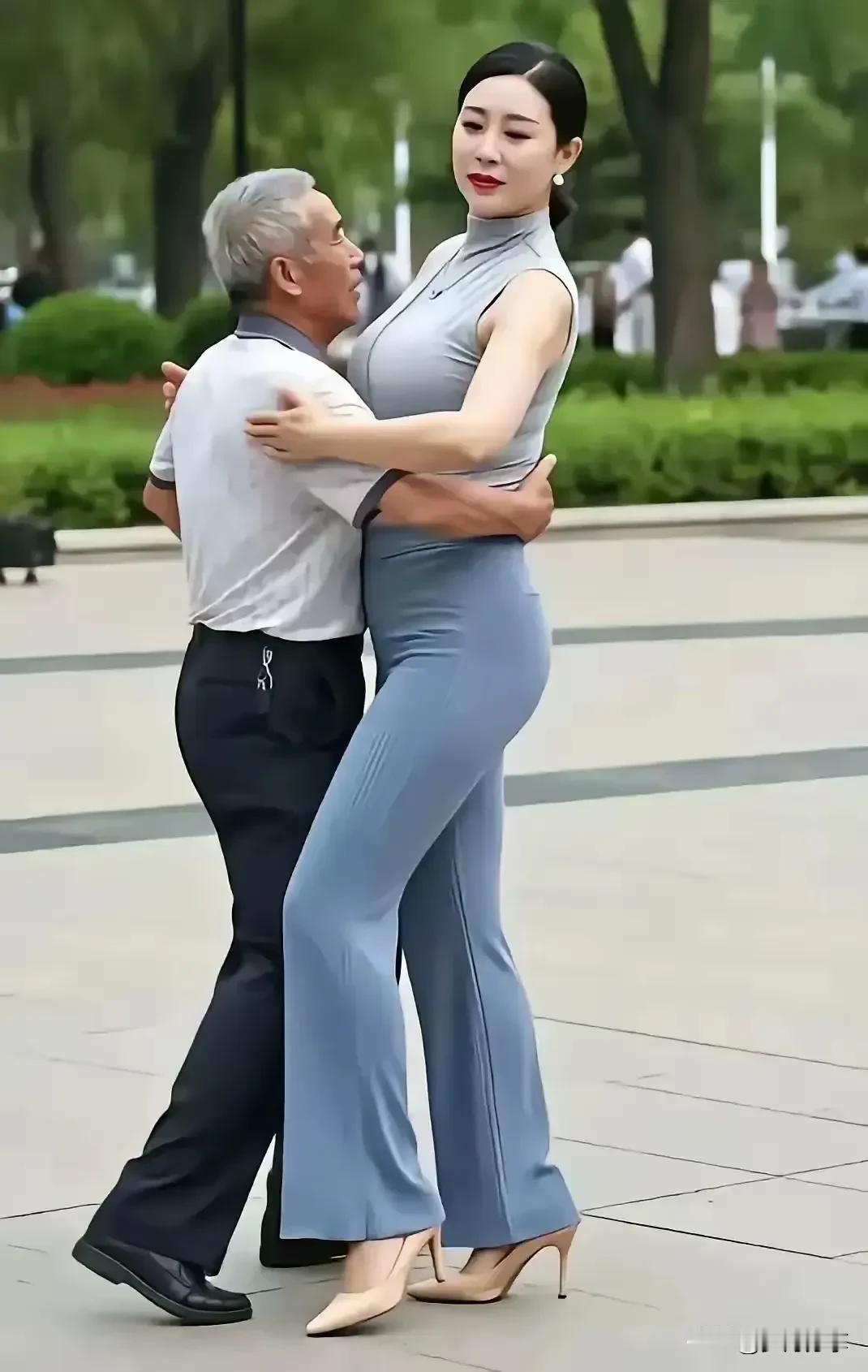 此交谊舞跳的有点别扭，女子比男子高很多，女高男矮，男子嘴巴正好与女人胸部在一条平