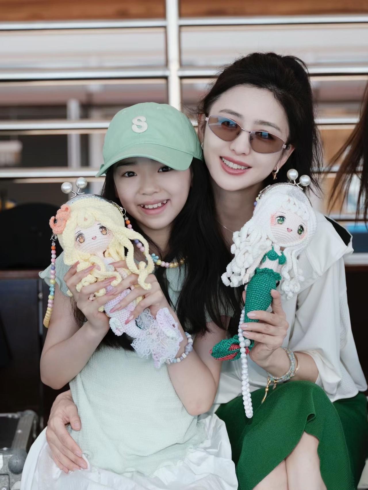 佟丽娅是真爱小酒窝，
与小酒窝穿着同色系衣服，
一起拿着美人鱼小娃娃，
亲昵的搂