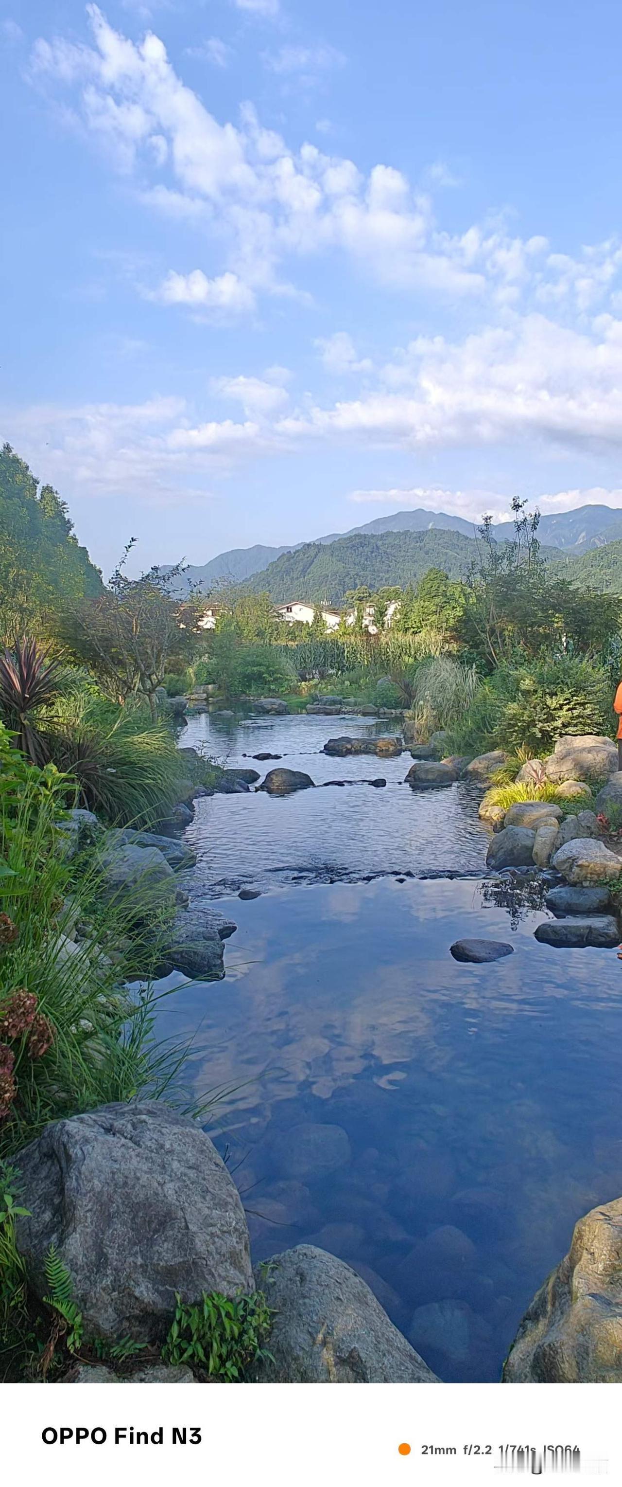 盛夏季节里的彭州宝山村的乡村田园，碧空如洗，白云蓝天，绿植婀娜，流水潺潺，气候宜